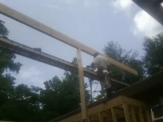 Carpenter setting a ridge beam over a new addition frame — Ice Dam Removal by Roofing Brothers in Shoshone