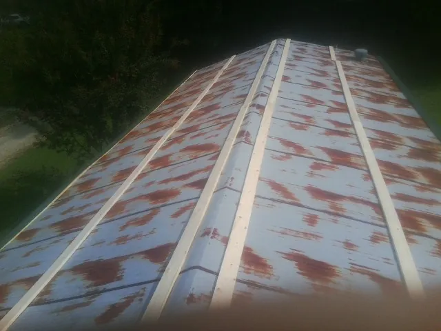 Rusted metal roof panels with new wood purlins before replacement — Storm Damage Roof Repair in Shoshone by Roofing Brothers