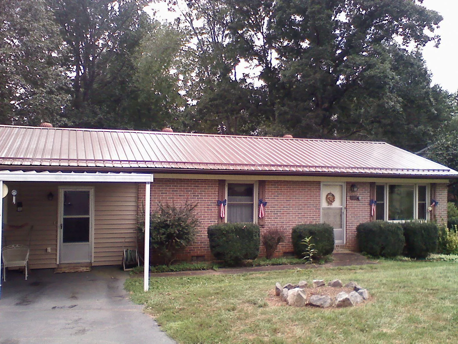 Bronze metal roof and carport on a brick ranch home in Shoshone