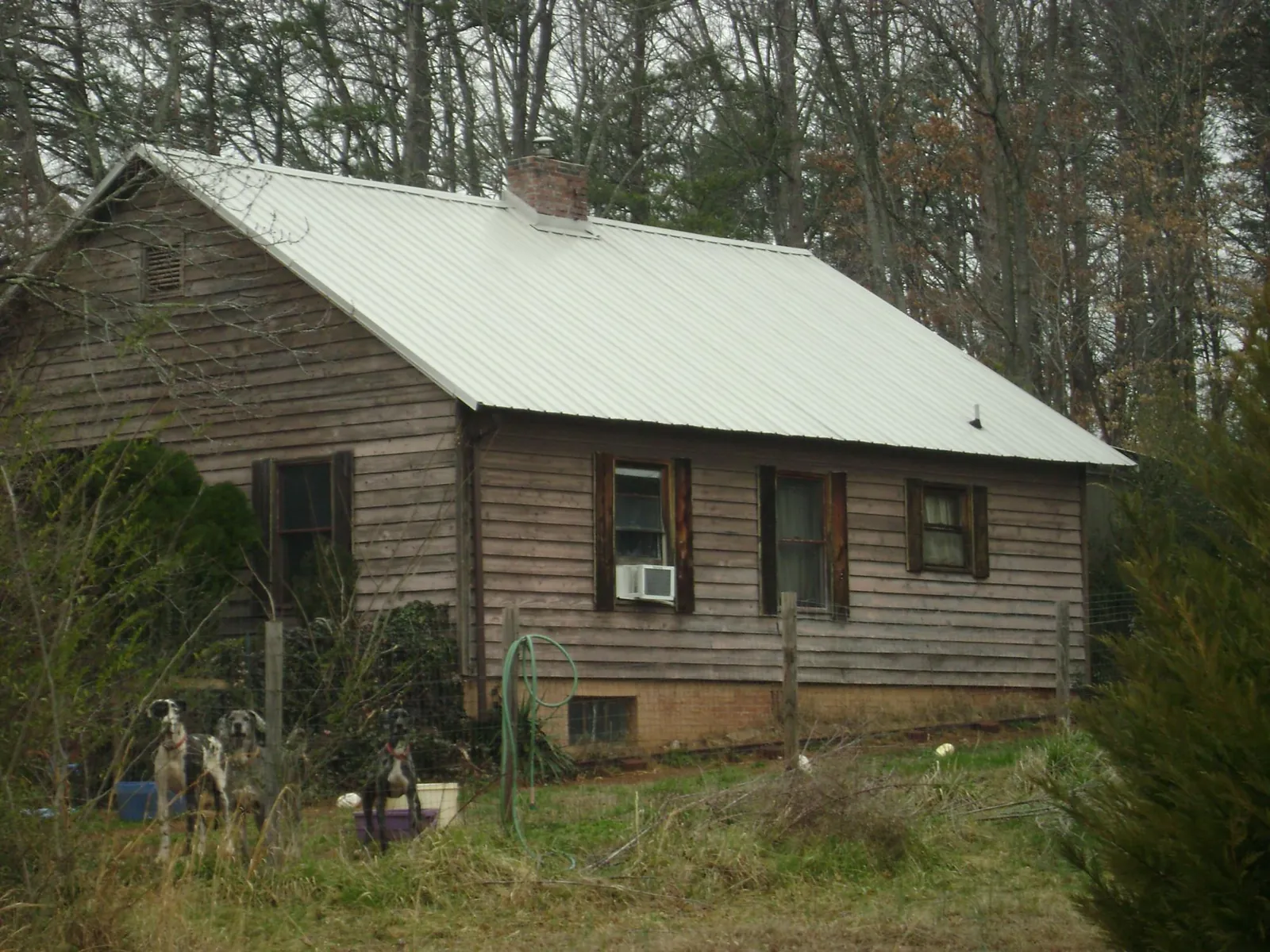 White metal roof on an old wood sided farmhouse, from a Metal Roof Installation job in Shoshone